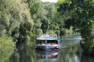 Barco navegando em trecho arborizado do Spree.